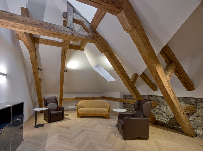 Sanierung und Erweiterung Psychiatrie Obwalden – Ruheraum mit bauzeitlichen Dachstuhl und sichtbarem Bruchsteinmauerwerk – Ben Huggler Photography